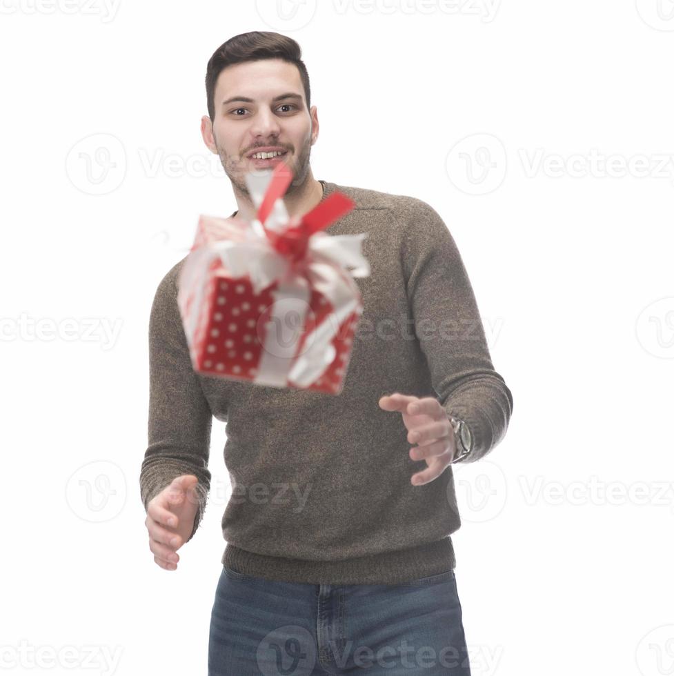 Young handsome man holding birthday present, looking positive and happy standing and smiling with a confident smile photo