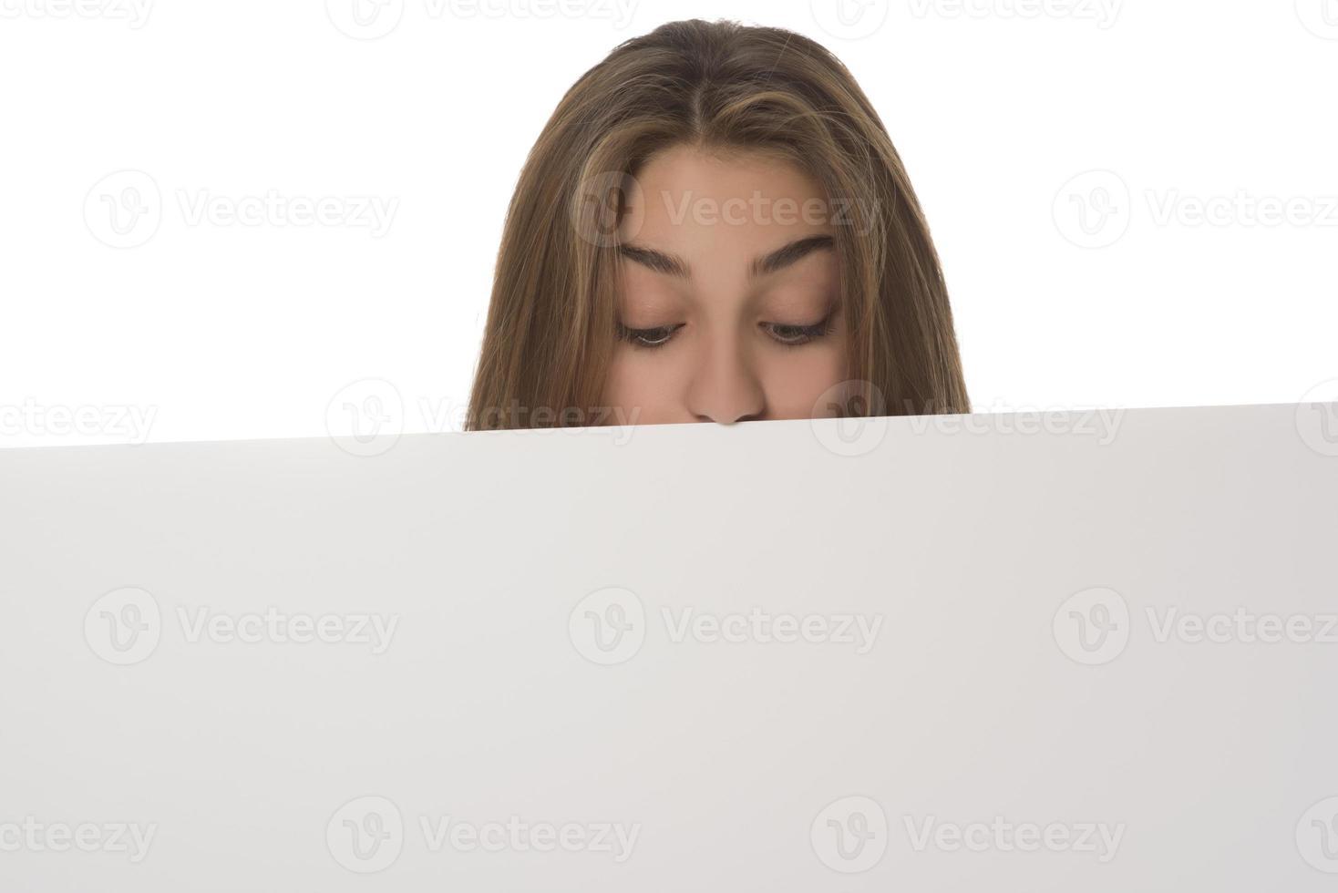 young smiling woman holding a blank sheet of paper for advertising photo