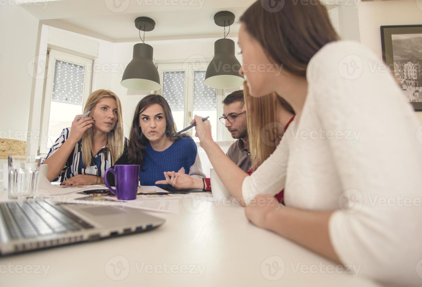 business woman explaining business matters to her team in a boardroom photo