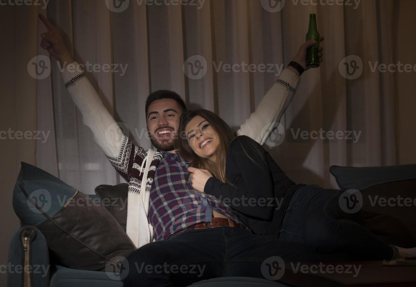 pareja divirtiéndose viendo un partido de fútbol en la televisión foto