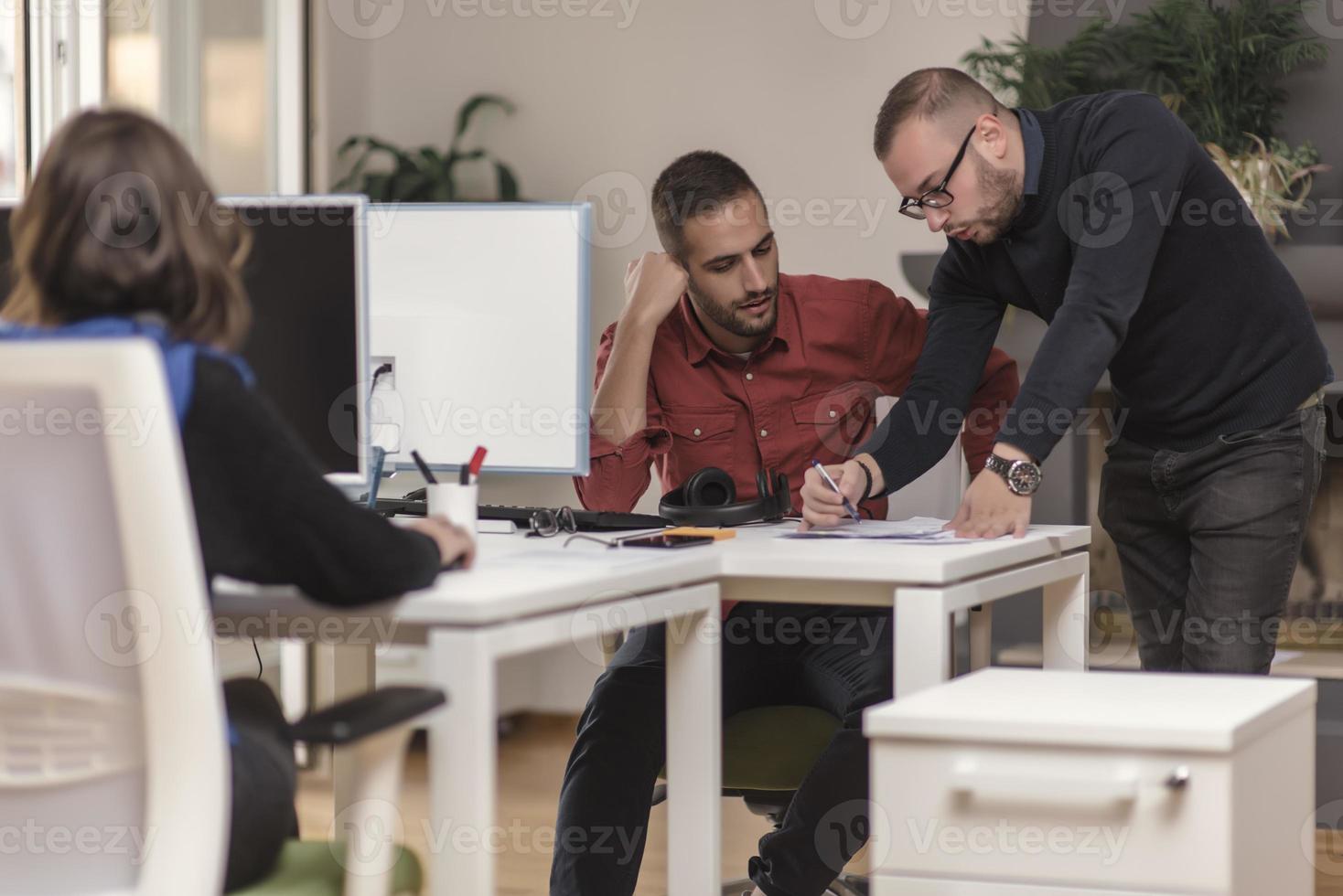 Two partnerships developing programming and coding technologies working on laptop and analyzing together. photo