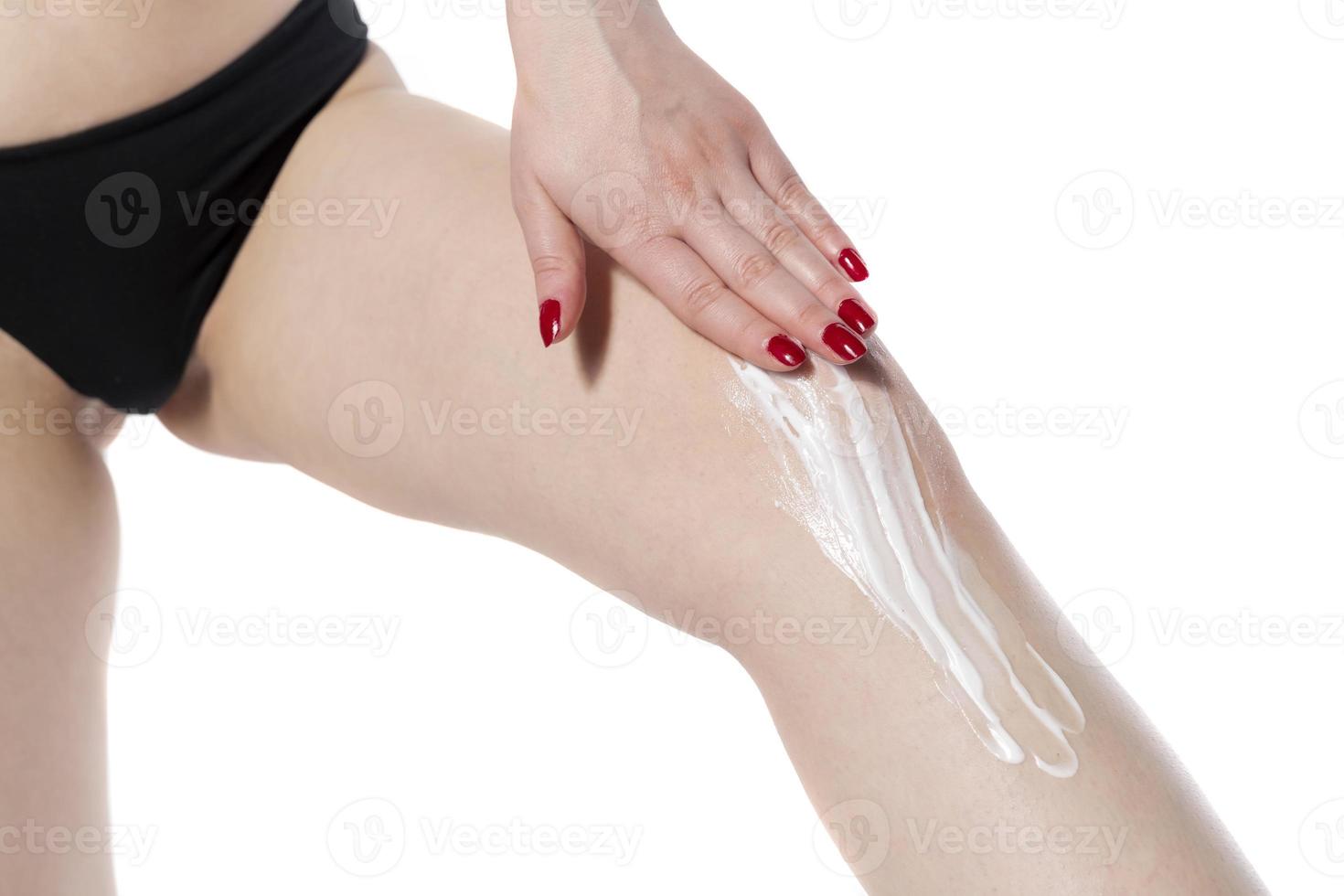 Woman Applying Cosmetic Foot Cream, Applying Cosmetic Cream after depilation, Skin Care. photo