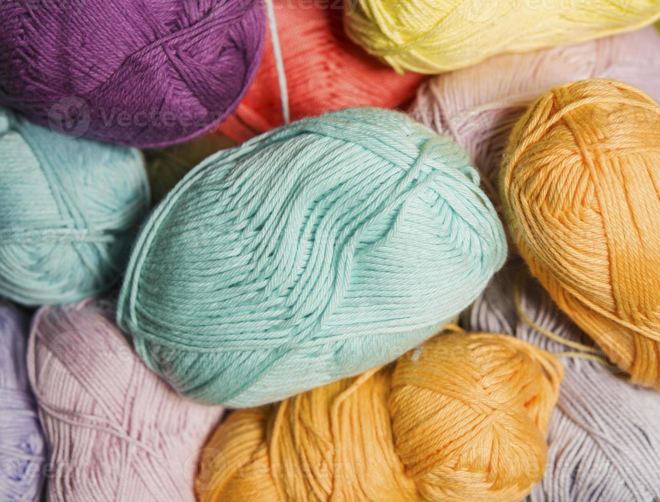 Colorful balls of wool on wooden table. Variety of yarn balls, view from above. photo