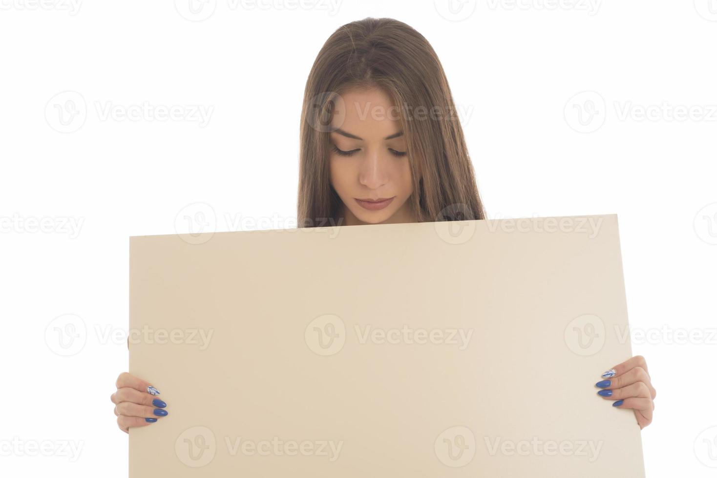 smiling girl holding blank sign board. studio portrait of young woman with sign card. isolated. photo