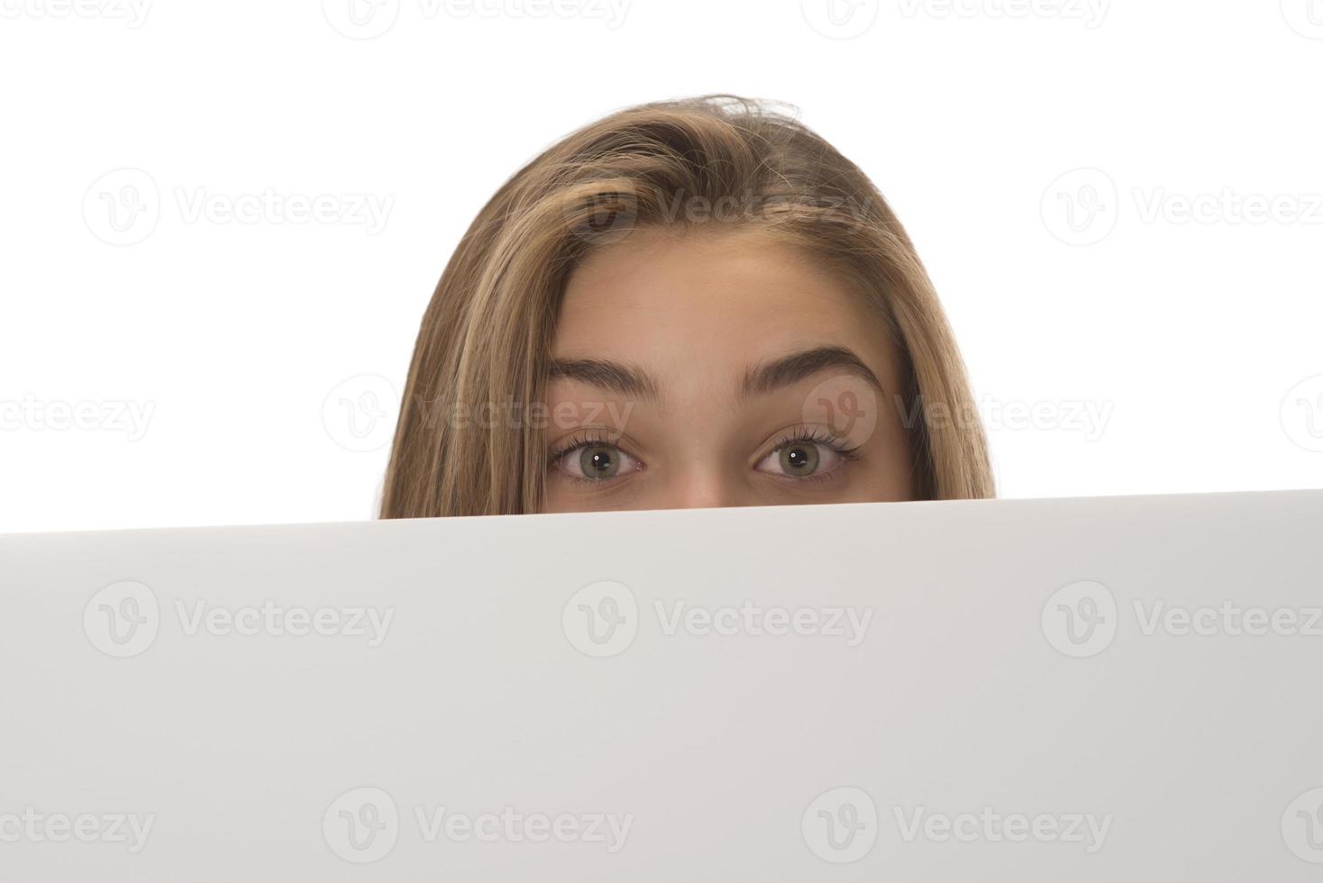 young smiling woman holding a blank sheet of paper for advertising photo