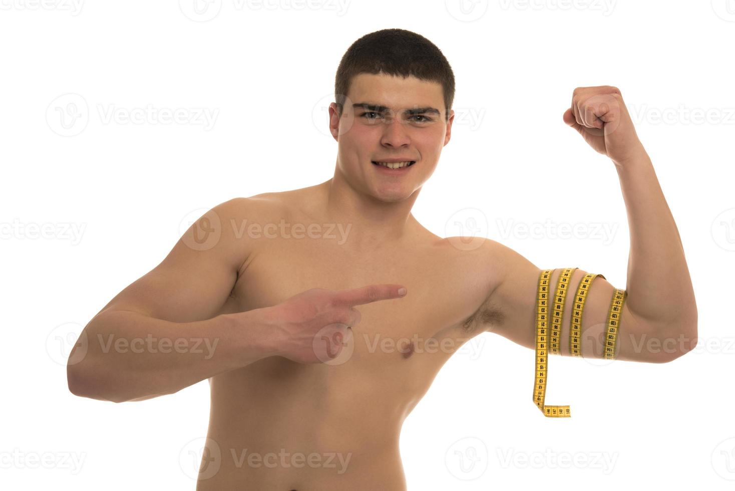 male model with great body measuring his body with measuring tape photo
