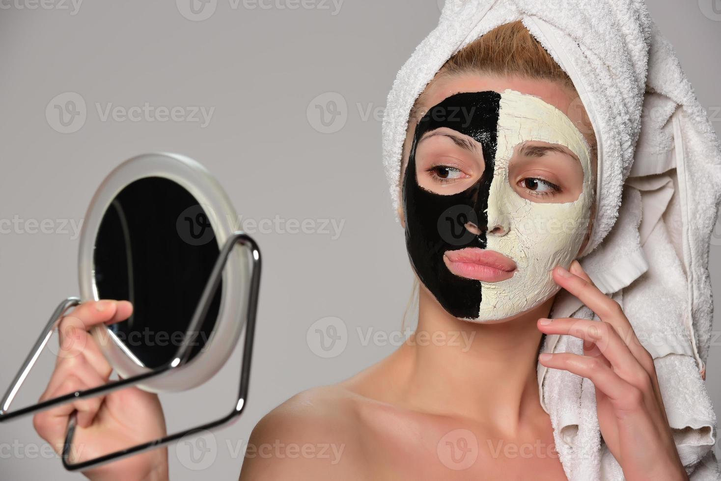 beautiful female model with black and white facial cosmetic mask photo