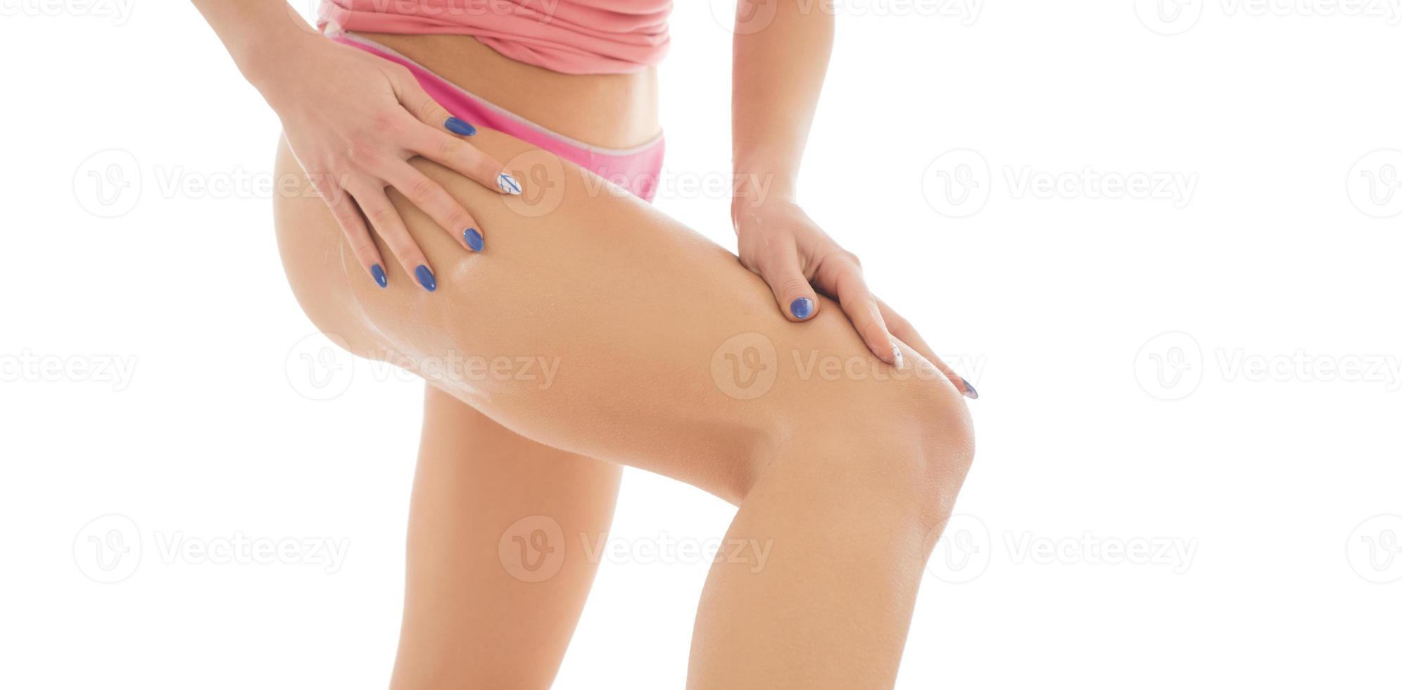 Body care. Unknown Woman applying cream on legs. Female applying anti cellulite cream photo