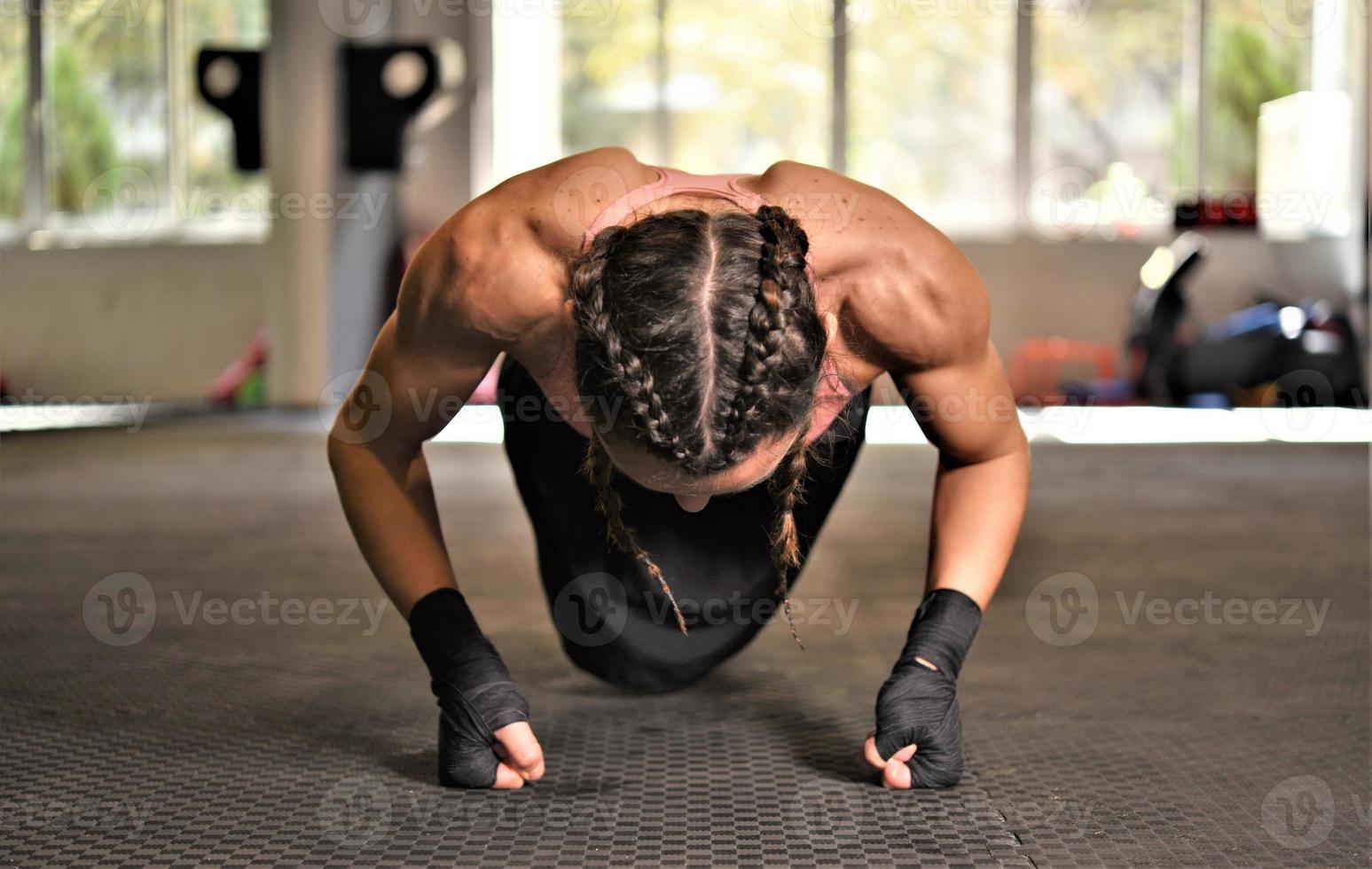 Woman on boxing training doing push ups photo