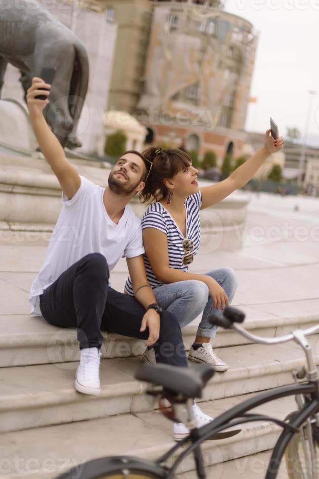 un par de turistas divirtiéndose caminando por las calles de la ciudad en vacaciones - amigos felices riéndose juntos en vacaciones - concepto de personas y vacaciones foto