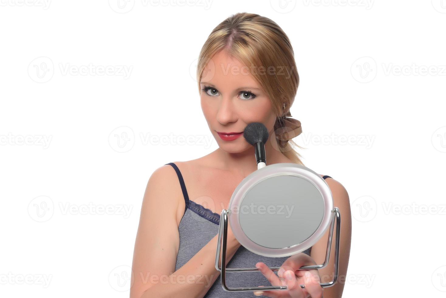 Image of joyful woman smiling at camera and using makeup brush photo