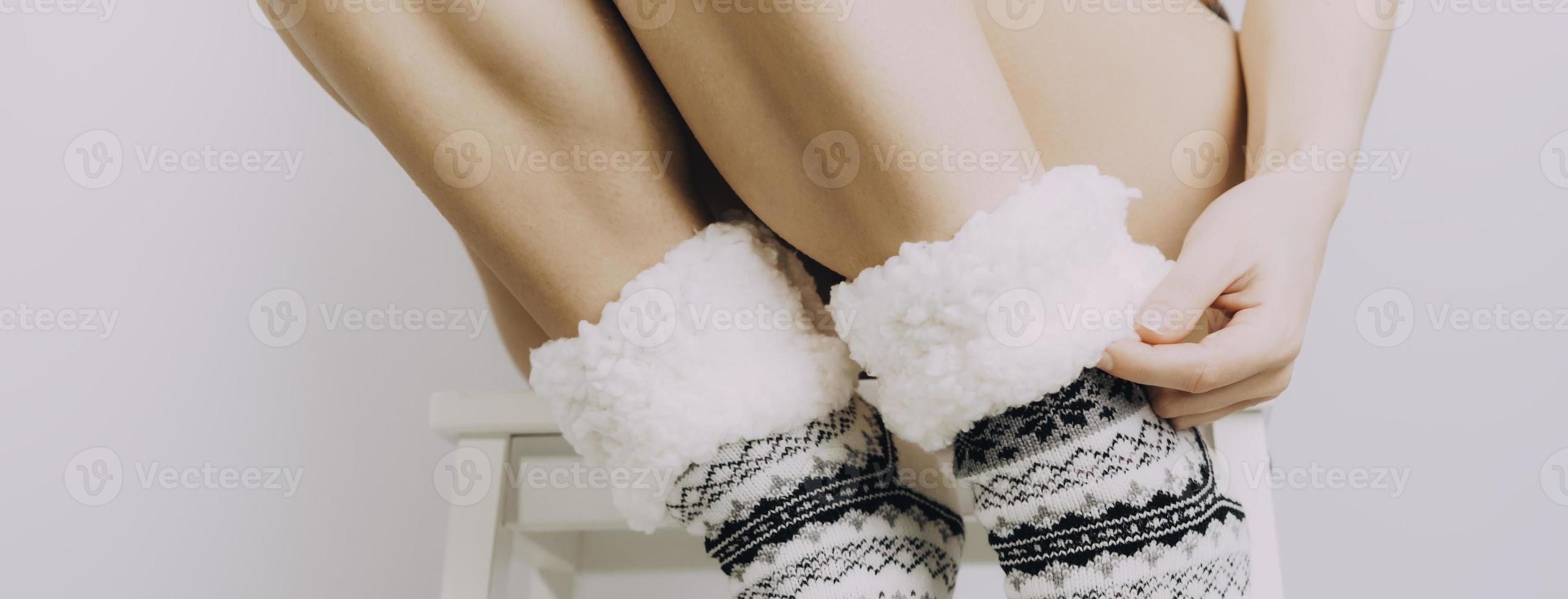 Cozy winter evening , warm woolen socks. Woman relaxing at home. Comfy lifestyle. photo