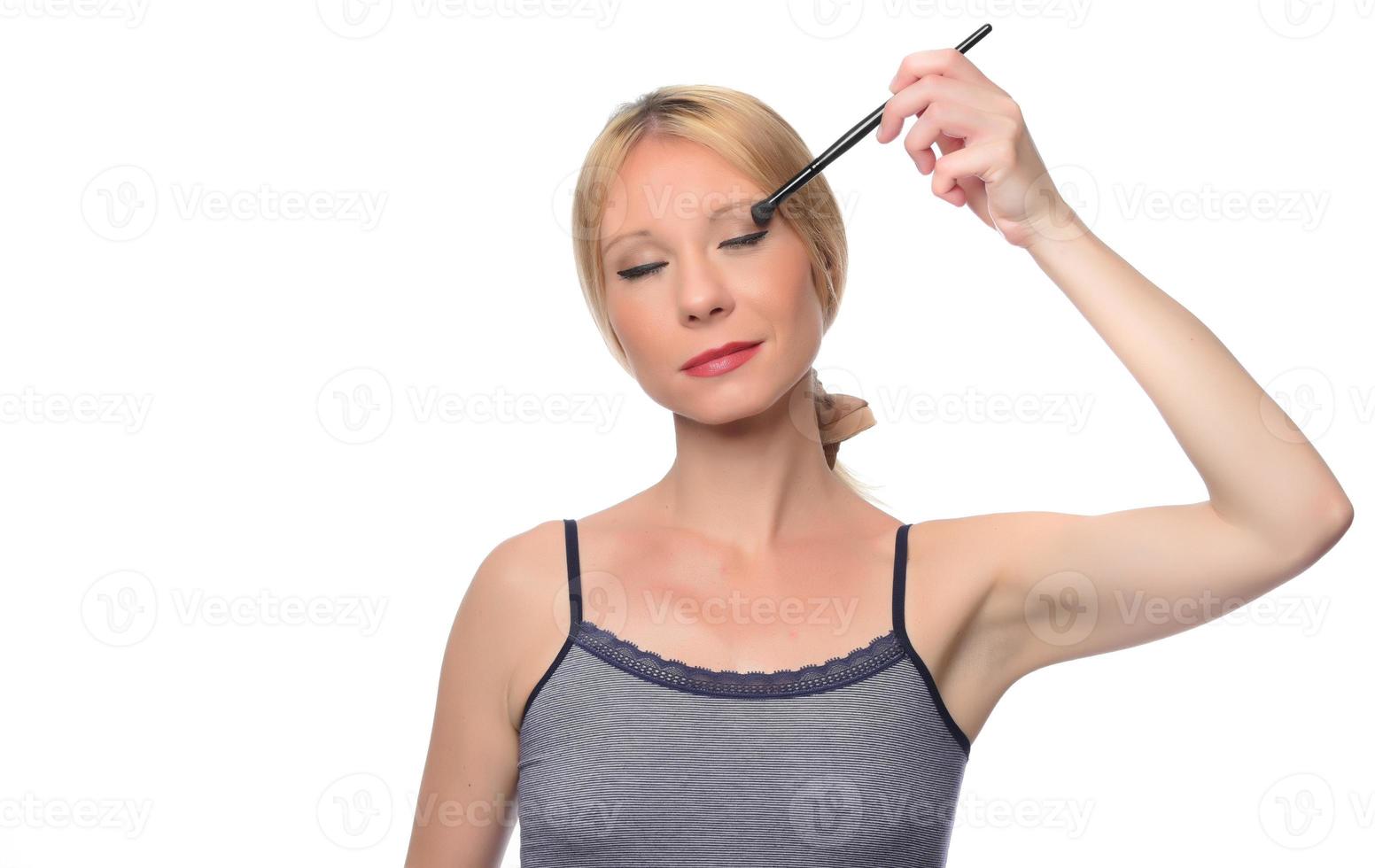 beautiful young smiling woman apply makeup with brush. isolated photo