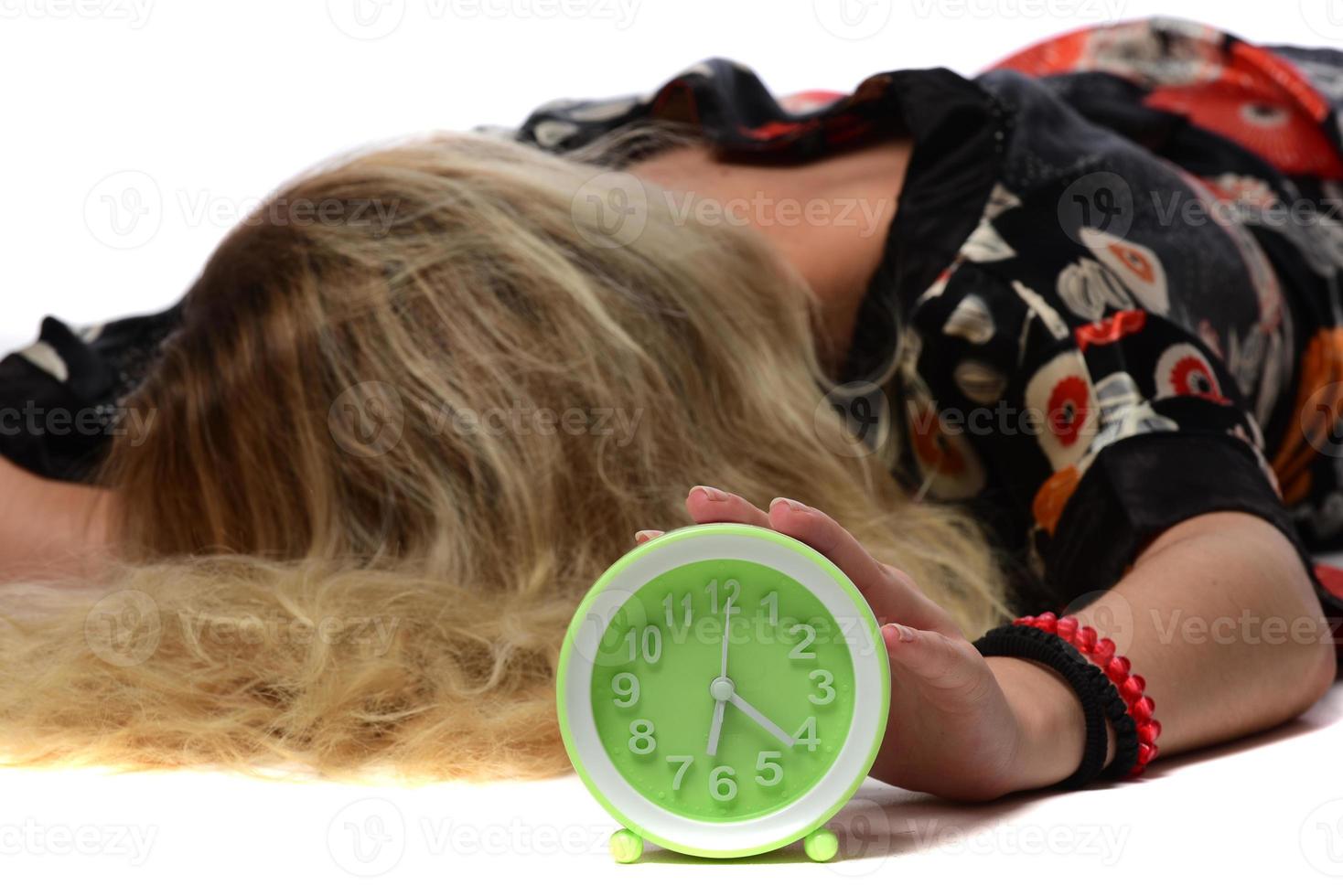 Happy young woman holding clock over isolated white background photo