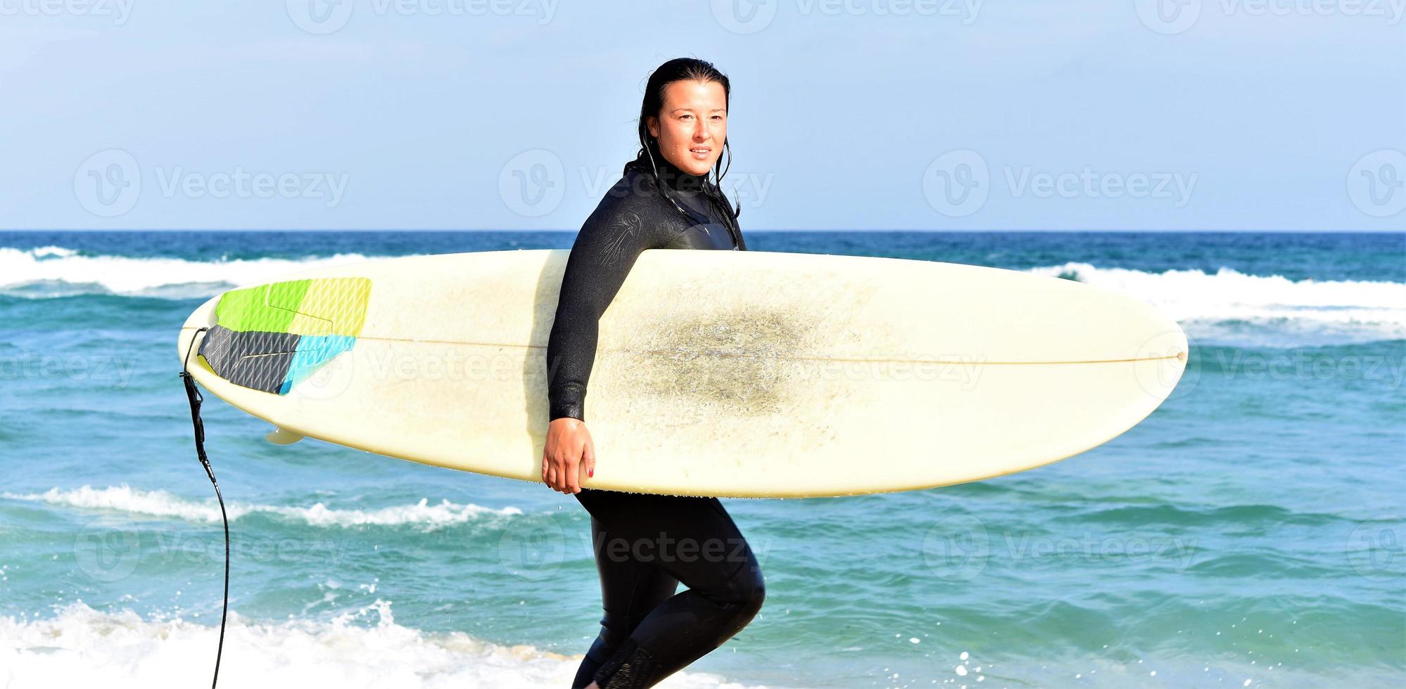 Beautiful sexy surfer girl on the beach photo