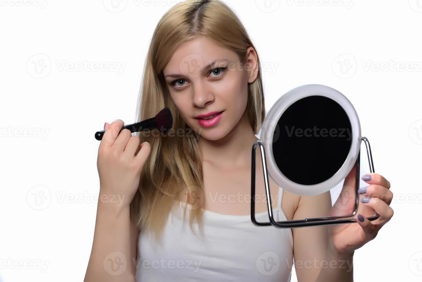 Young woman doing makeup. photo
