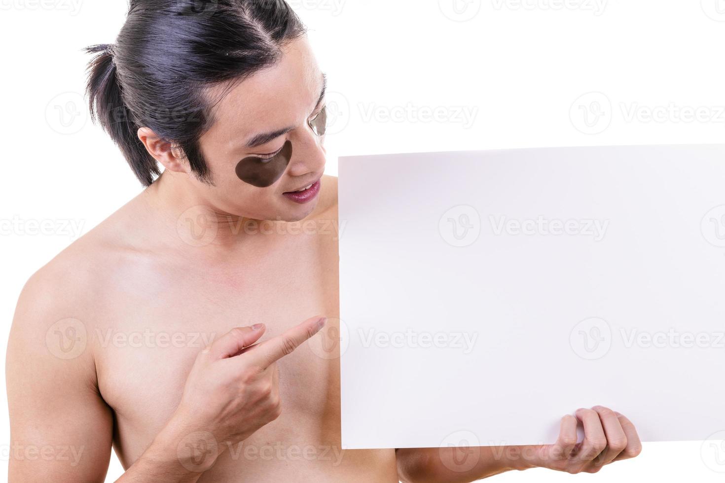 Portrait of young Asian man peeping at the camera holding white blank sign photo