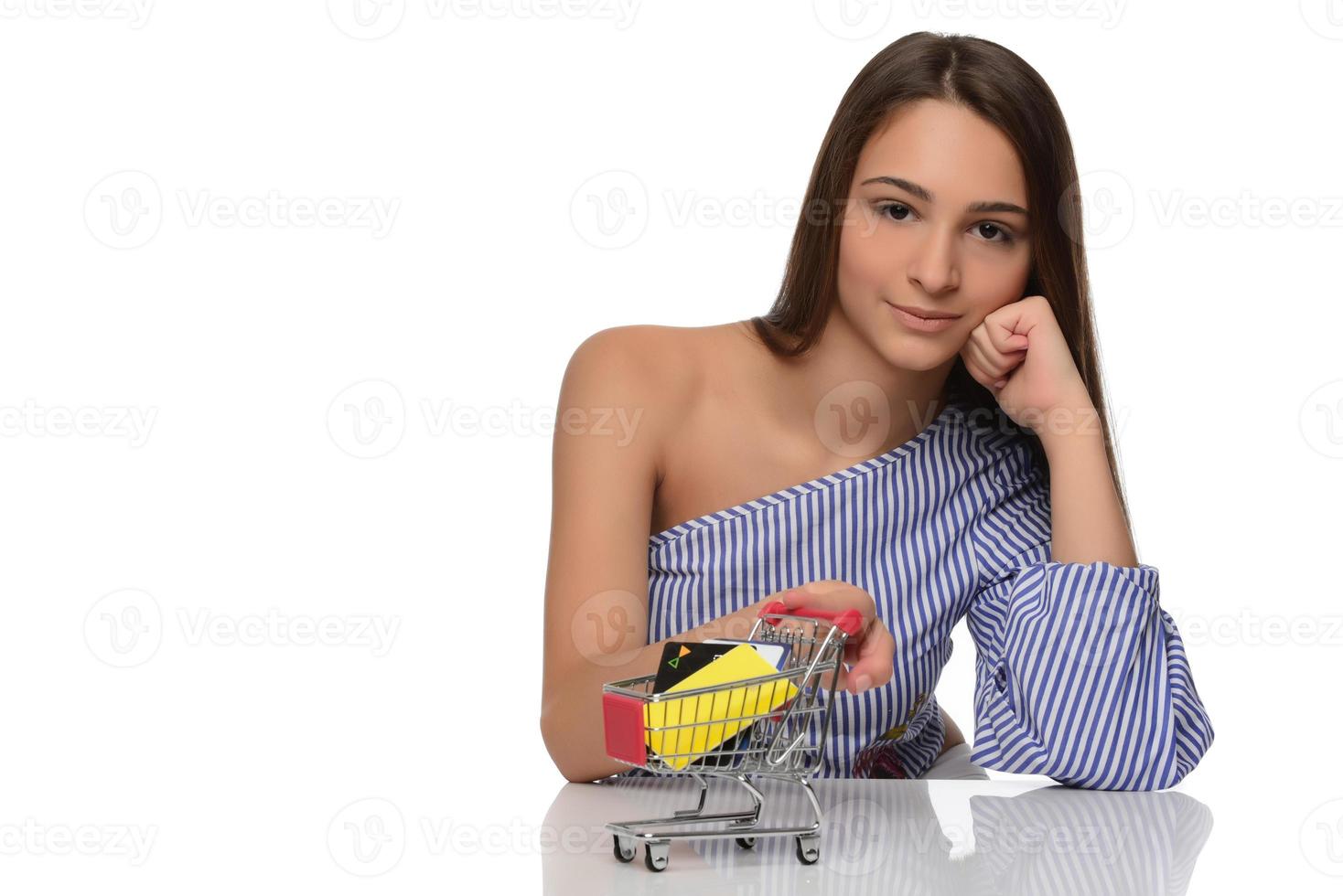 Credit card in a woman's hand and a small souvenir cart. Shopping, wholesale and retail trade, discounts, purchases on credit, credit history. photo