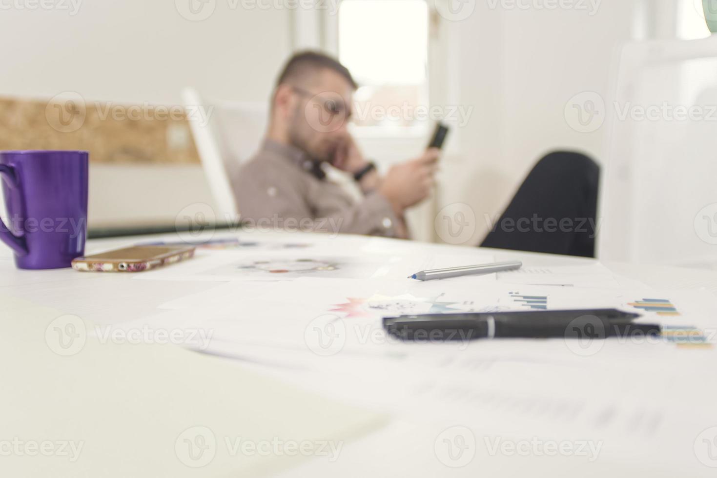 Young business man working at home with lpapers on desk photo