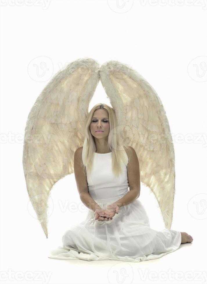 Portrait of beautiful blonde woman with angel's wings. Angel with long curly hair photo