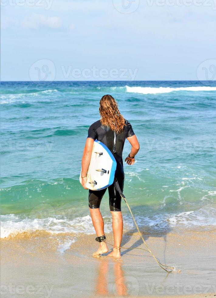 handsome surfer man on the beach photo