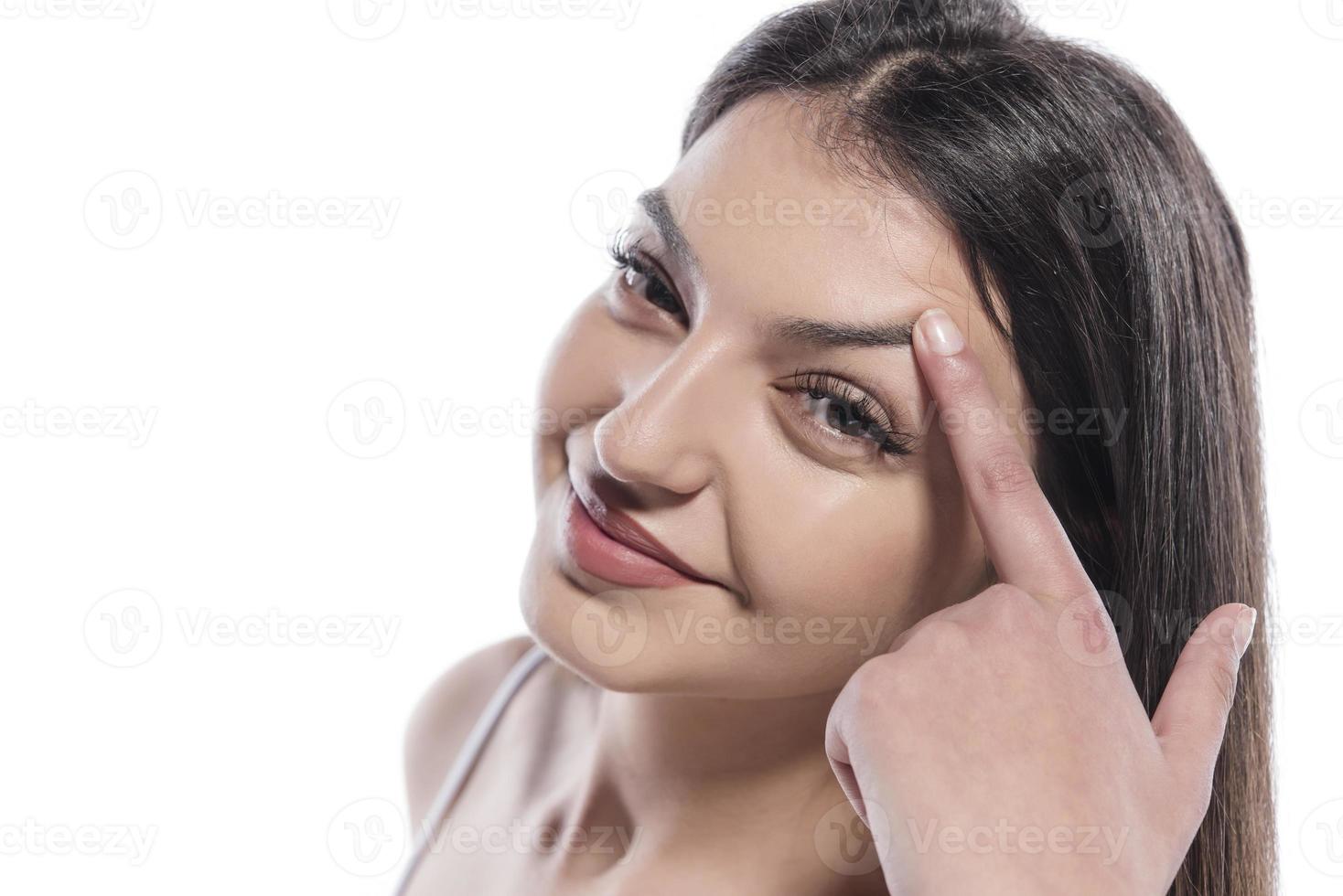 Portrait of a girl putting cosmetic ointment on face while watching at mirror indoor photo