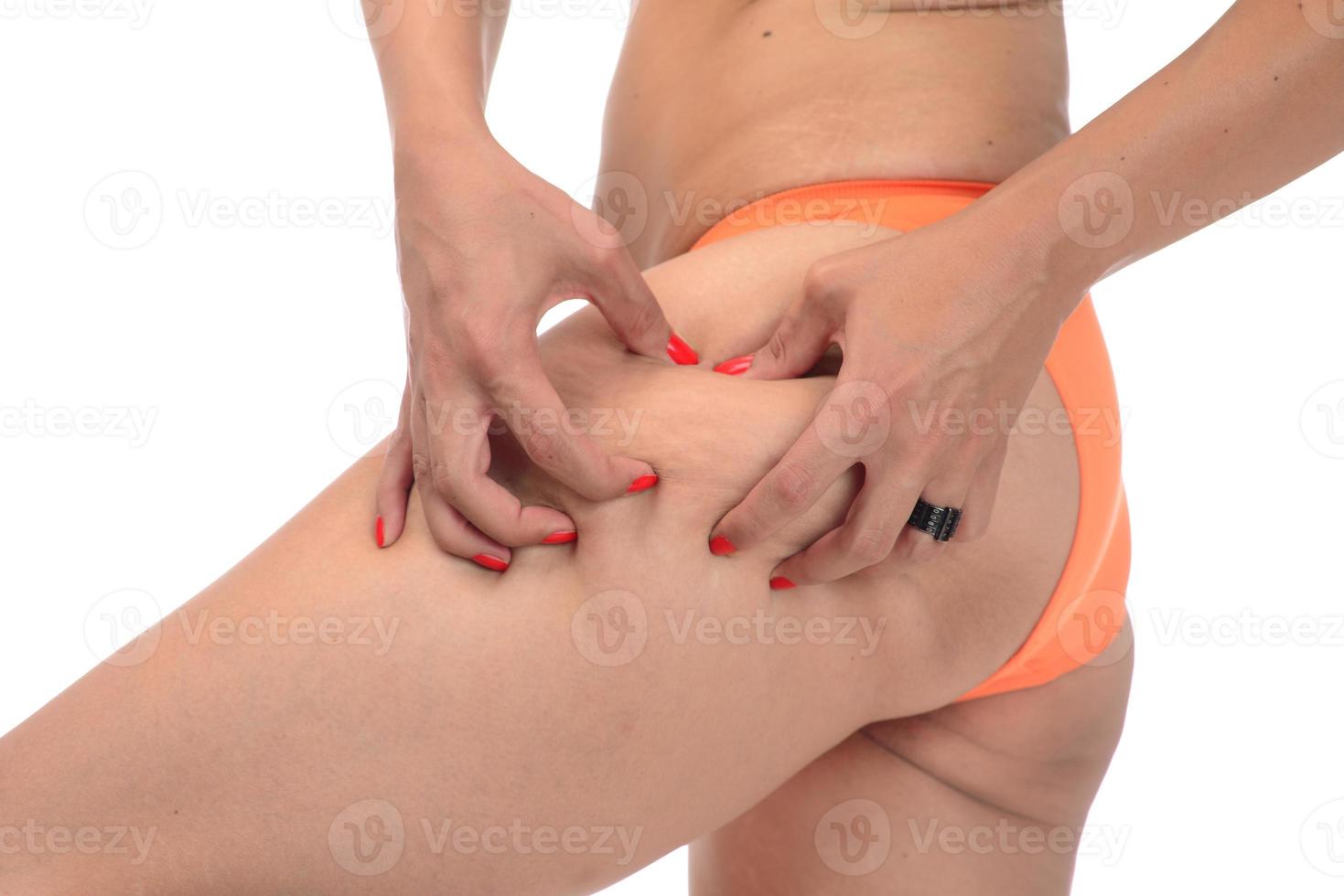 fat female woman pinching her fat on her hips, isolated on white background. photo