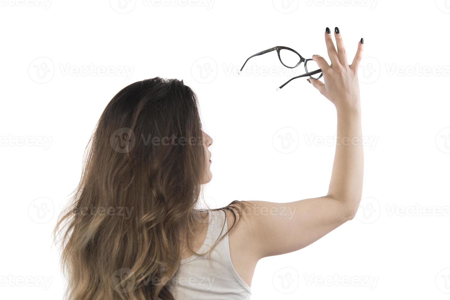 back view of a beautiful young woman holding eyeglasses photo