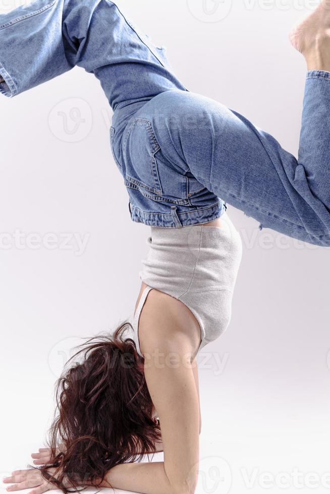 Portrait of beautiful young woman with athletic flexible body doing leg stretching. isolated photo