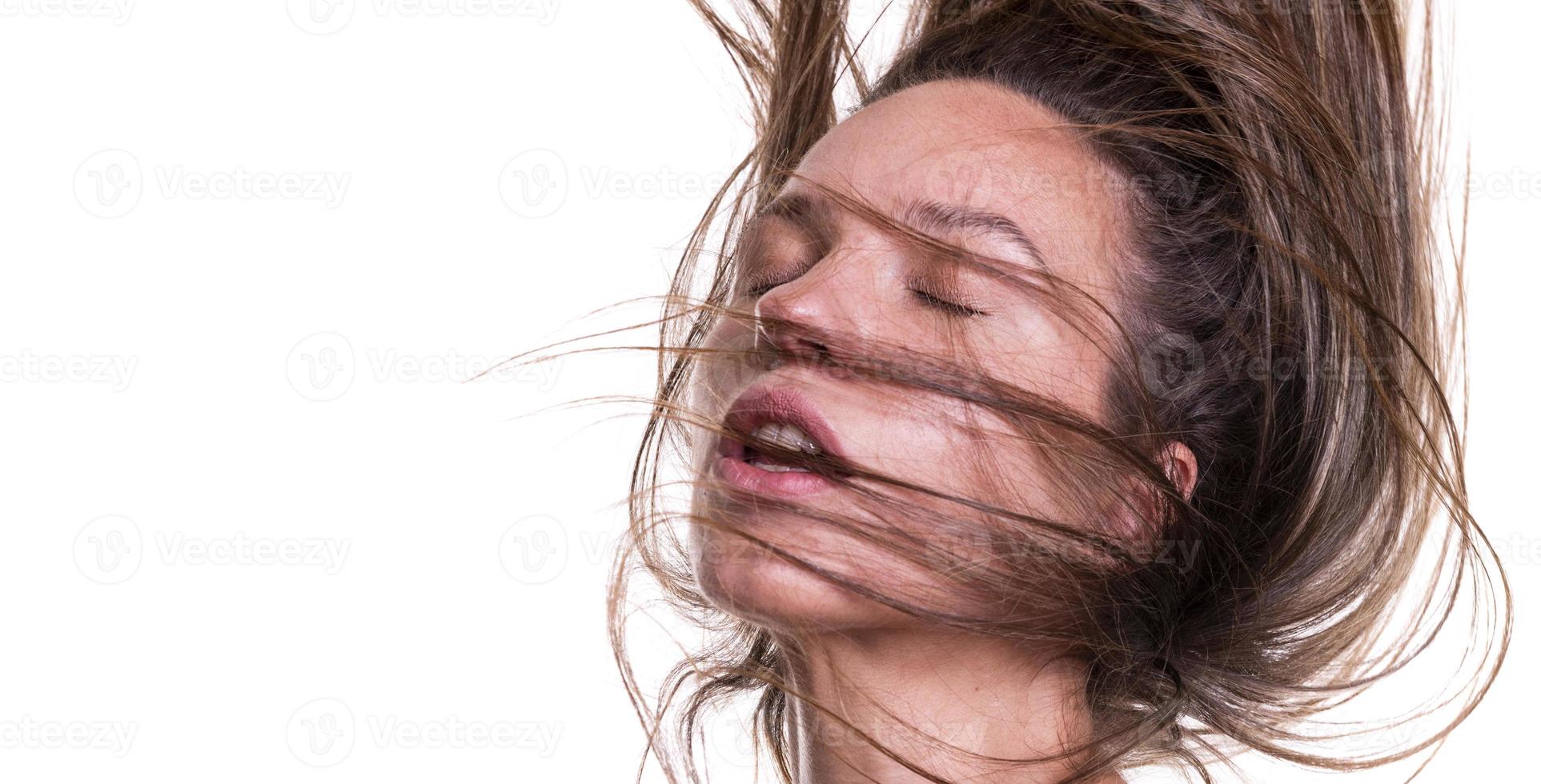 Portrait of a beautiful woman with a long hair. Young brunette model with beautiful hair - isolated on white background. Young girl with hair flying in the wind. photo