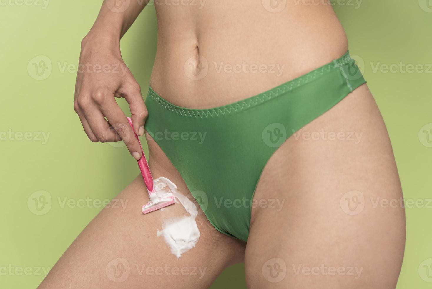 woman in panties shaved her crotch with razor photo