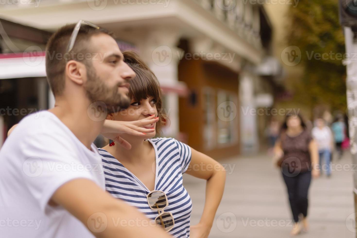 Couple of tourists having fun walking on city street at holiday - Happy friends laughing together on vacation - People and holidays concept photo