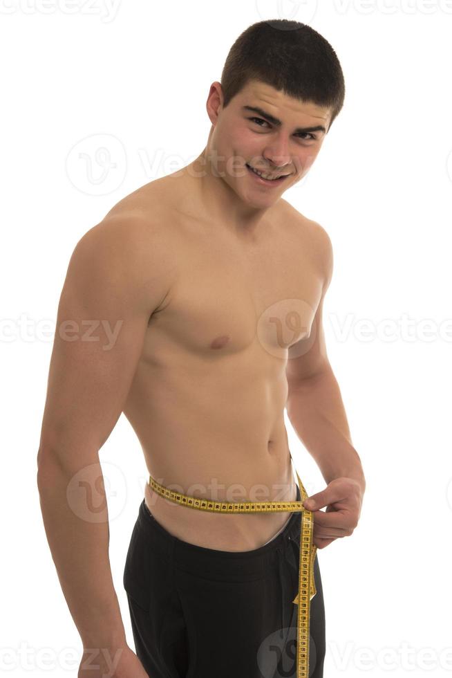 male model with great body measuring his body with measuring tape photo