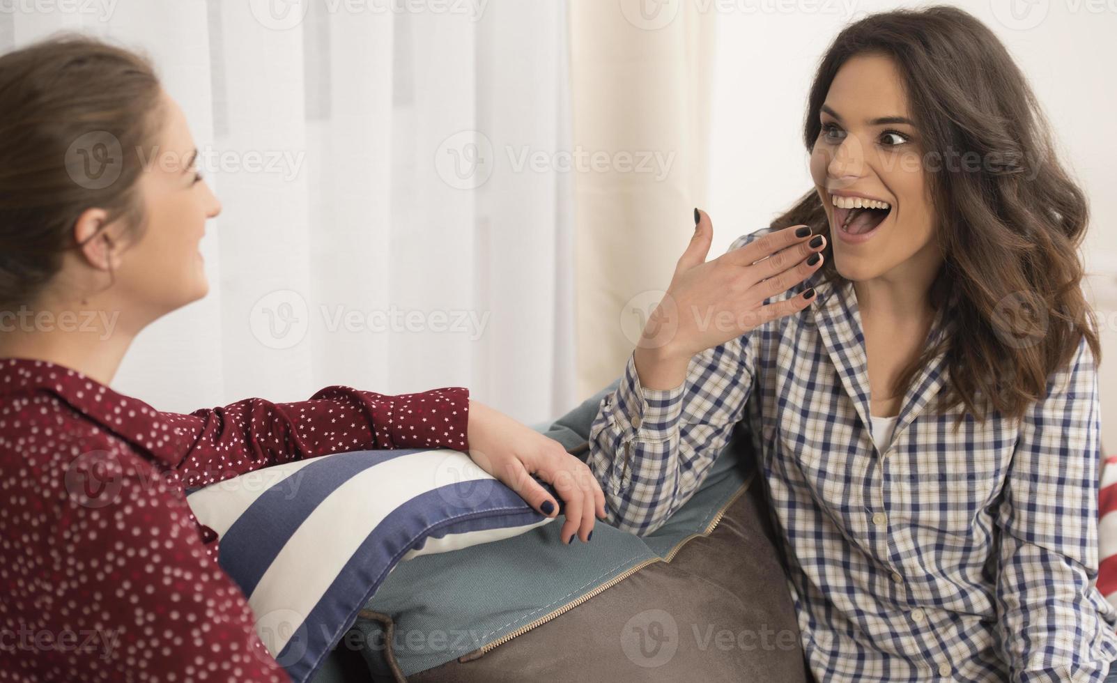 Best friends having fun at home. Young women having conversation. photo