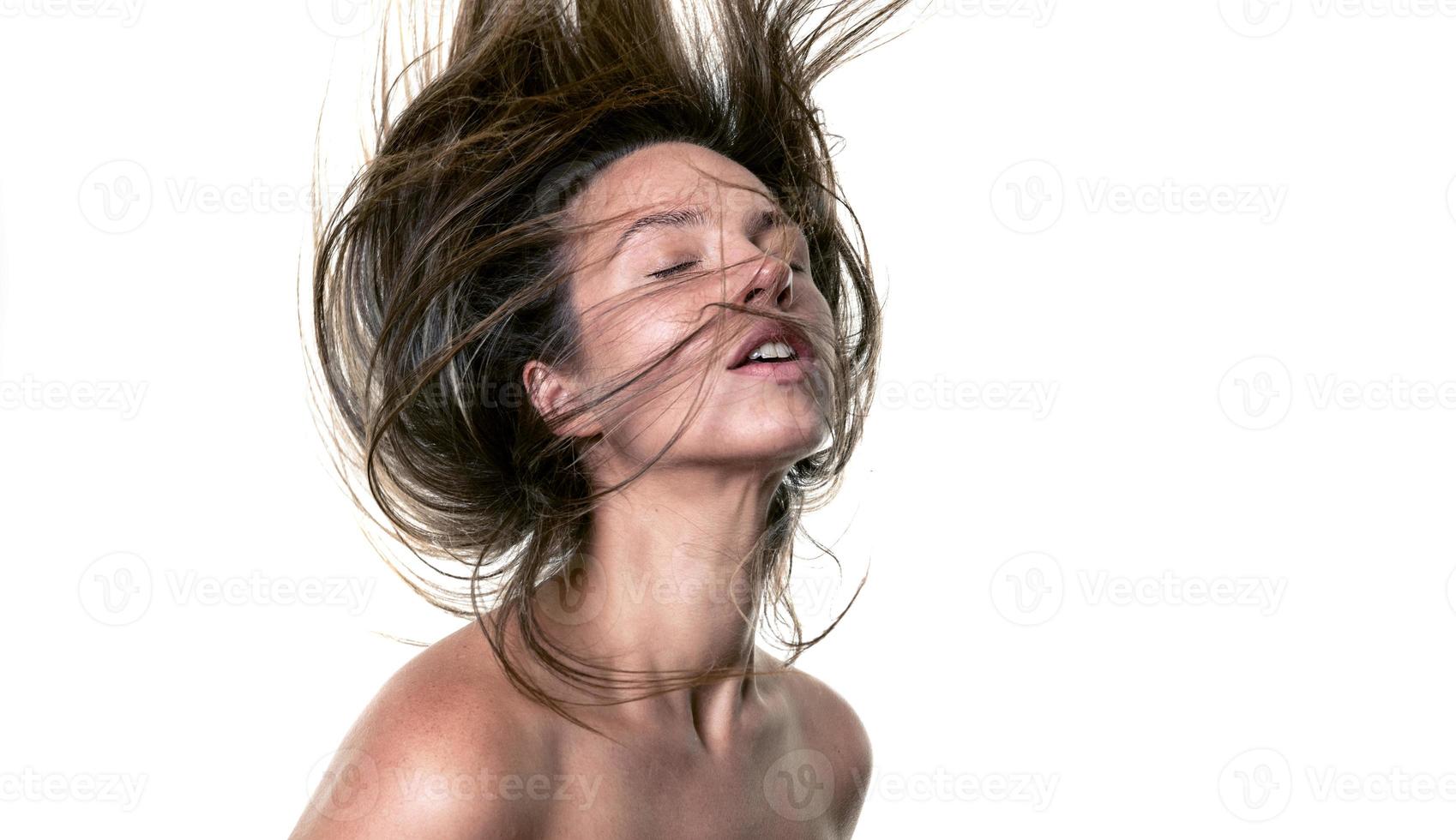 retrato de una mujer hermosa con el pelo largo. joven modelo morena con cabello hermoso - aislado sobre fondo blanco. niña con el pelo volando en el viento. foto