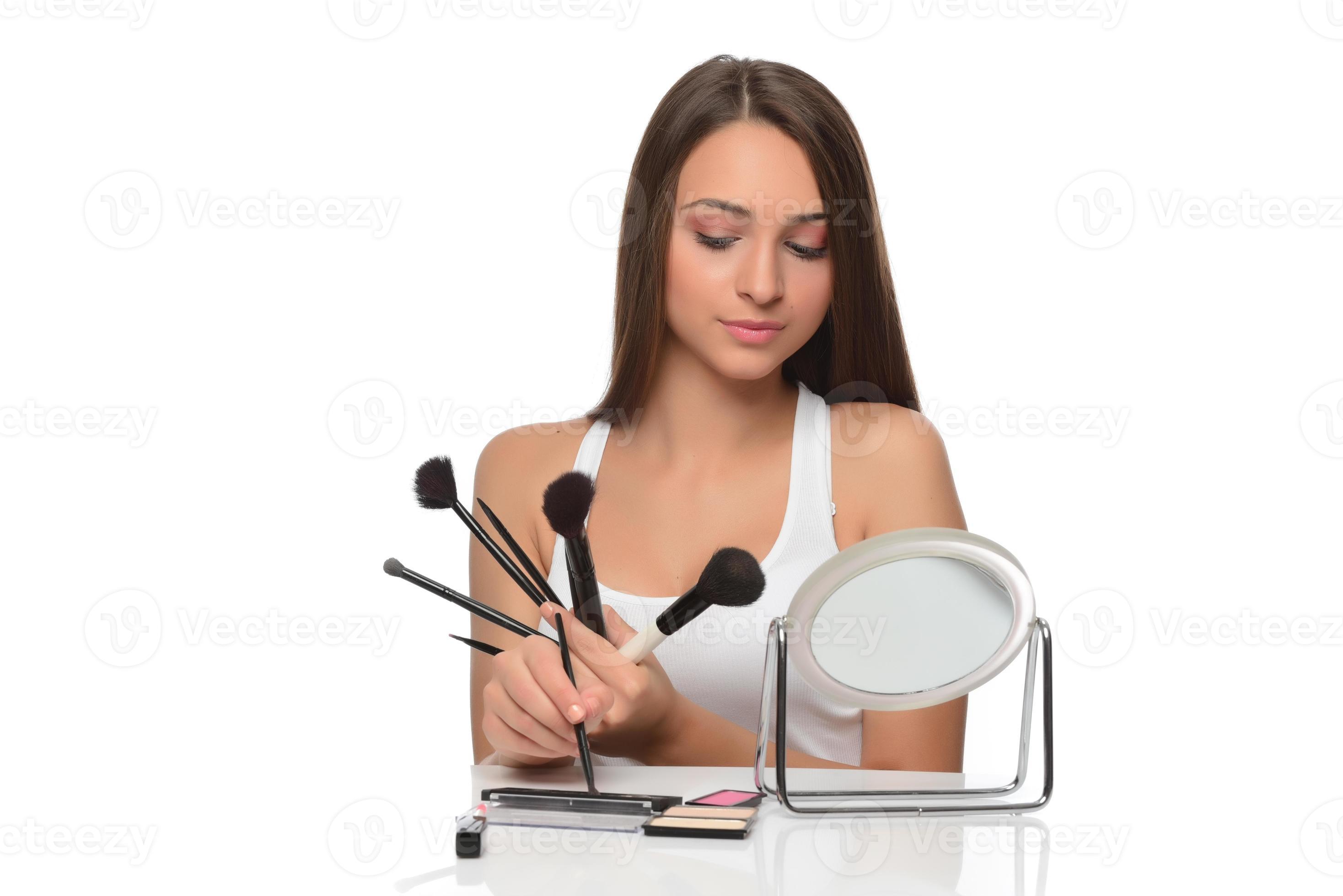 Makeup artist applies eye shadow . Beautiful woman with make-up face. Hand  of visagiste, painting cosmetics of young beauty model girl . Make up in  process Photos