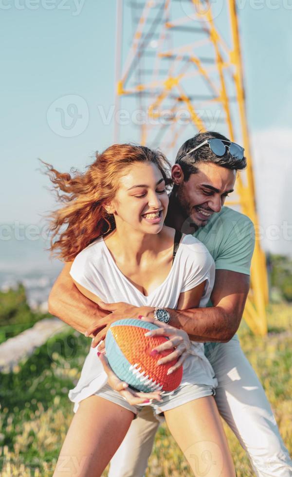 Couple playing American football on hot summer day. Couple playing Rugby photo shoot