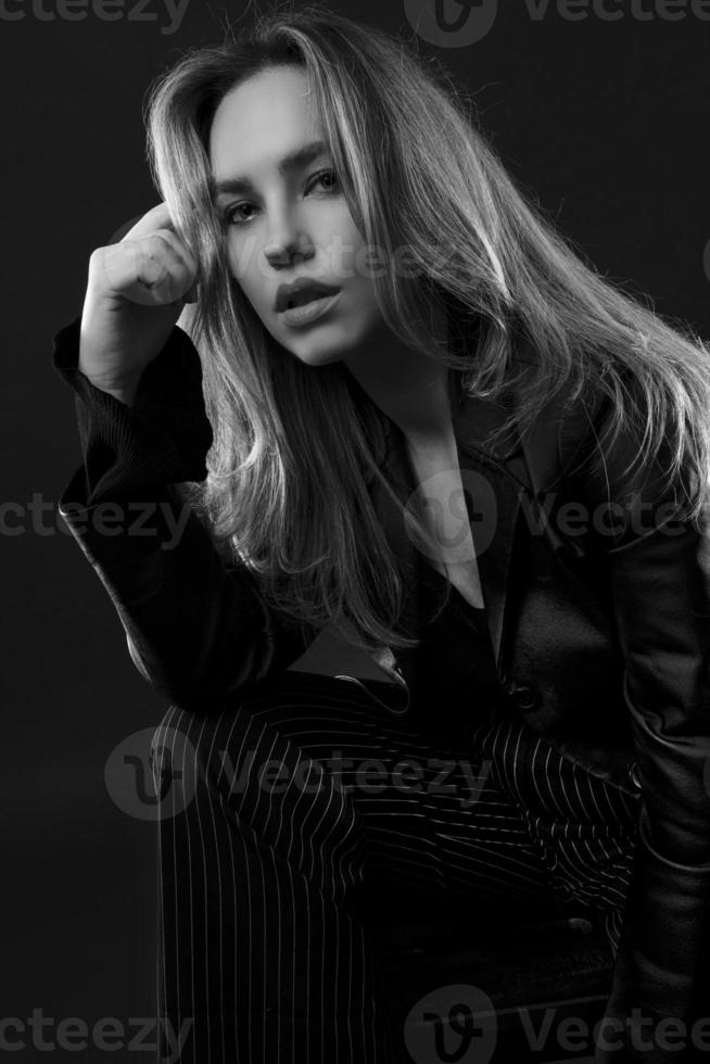 portrait of young beautiful fashionable happy woman on black background photo
