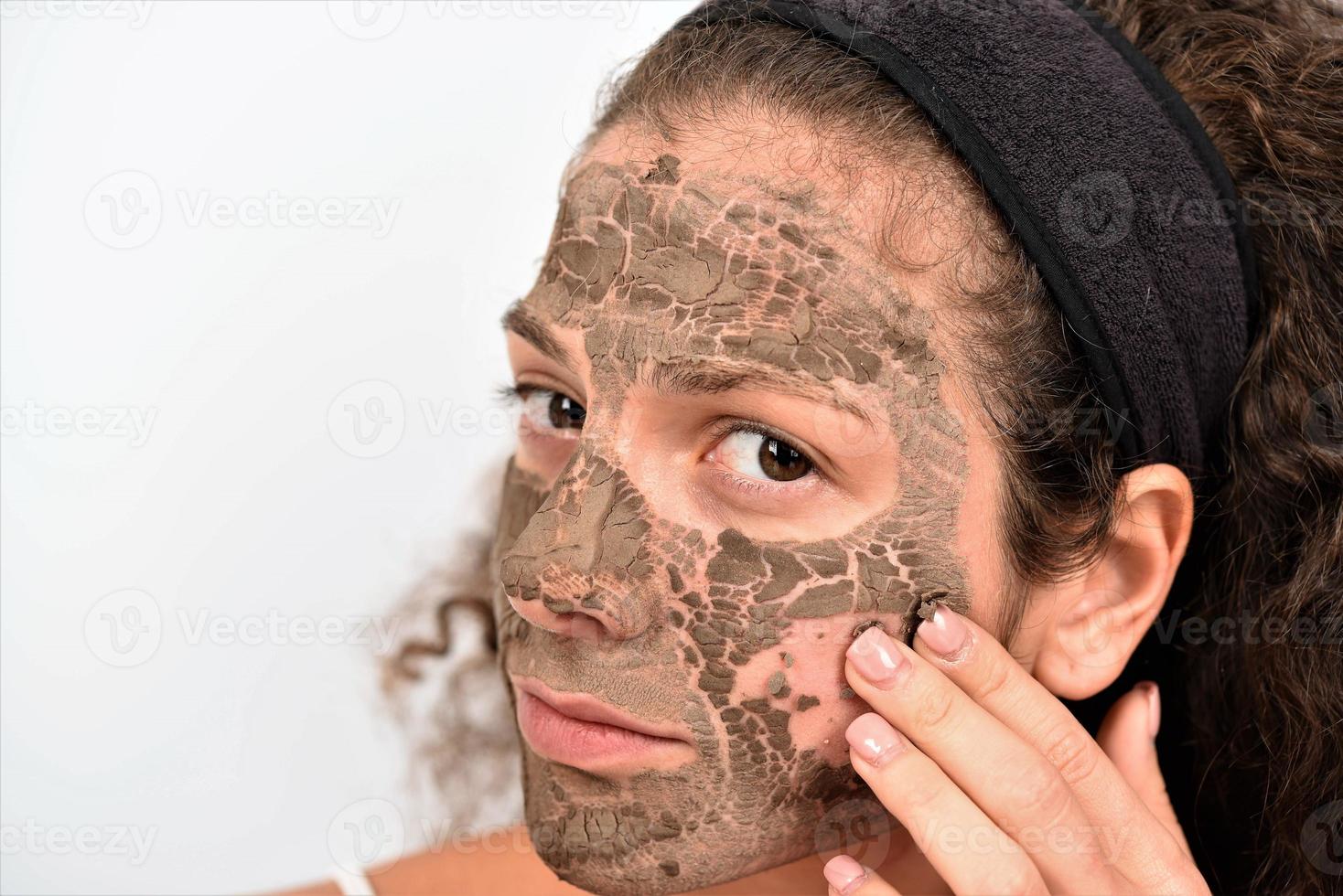 Beautiful woman having clay facial photo