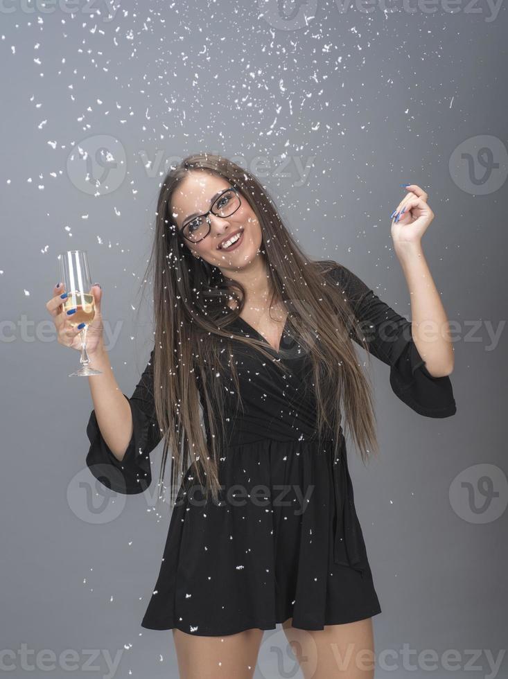 Beautiful woman celebrating New Year with confetti and champagne photo
