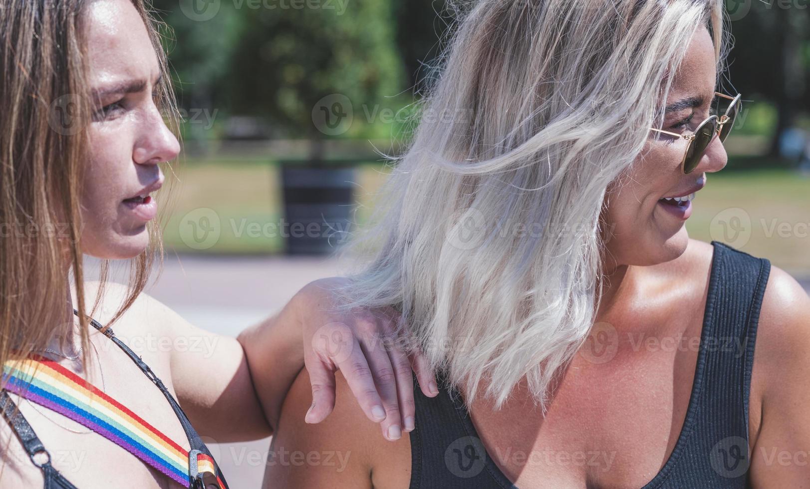 un par de mujeres gay sonriendo y besándose. pareja de mujeres jóvenes casadas del mismo sexo en su rutina diaria mostrando algo de afecto lgbt foto