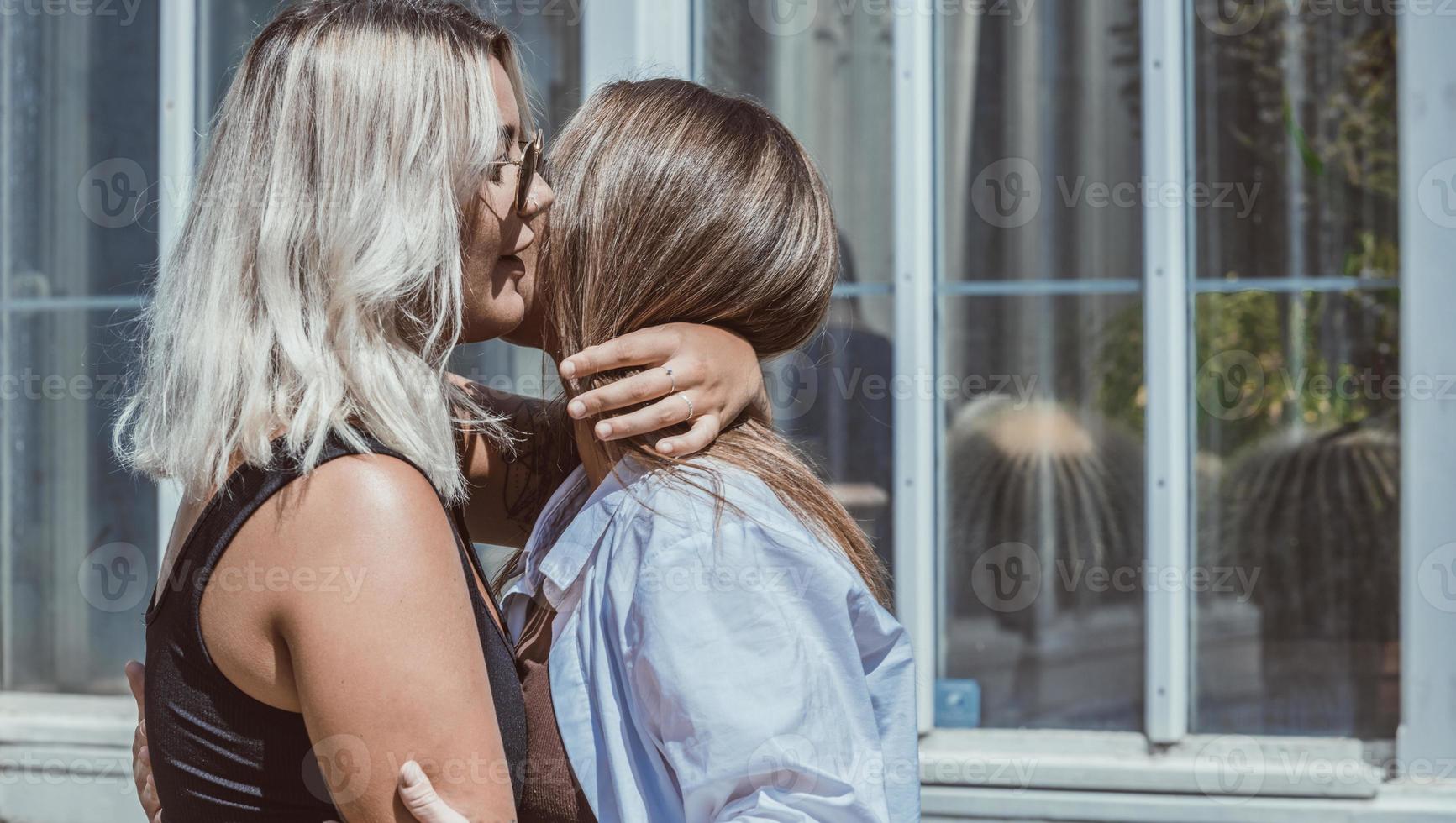 un par de mujeres gay sonriendo y besándose. pareja de mujeres jóvenes casadas del mismo sexo en su rutina diaria mostrando algo de afecto lgbt foto