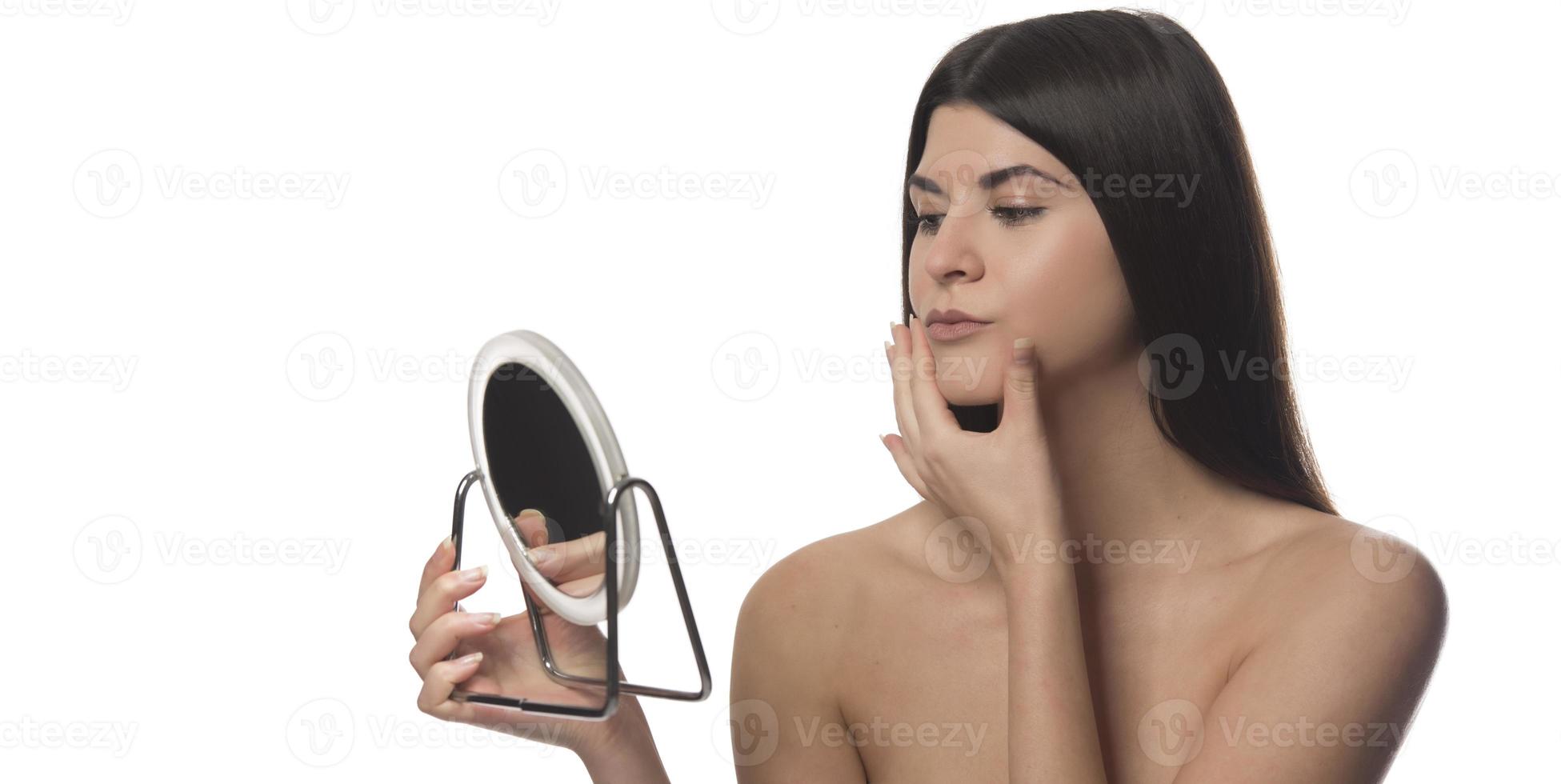 woman touches face skin looks at mirror feeling worried about first wrinkles and age-related changes derma problems. Cosmetic facial plastic surgery skincare treatments concept photo
