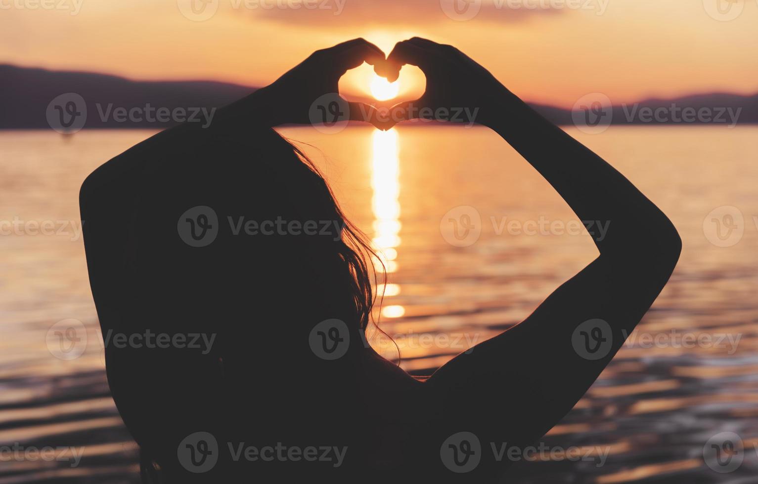 Silhouette hand gesture feeling love during sunset photo