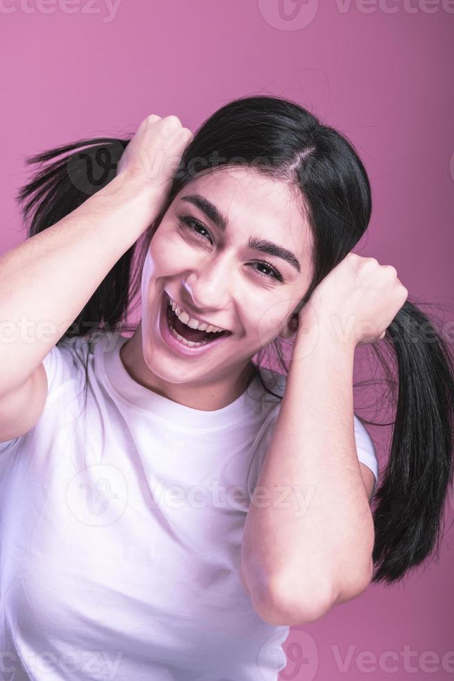 tudio shot of a young beautiful woman with long gorgeous hair posing and holding hair photo