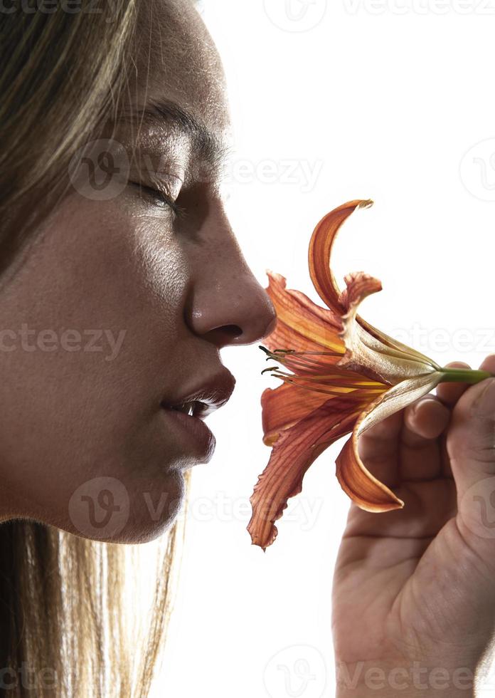 retrato artístico de una mujer sosteniendo una flor de lirio. concepto de belleza. aislado sobre fondo blanco foto