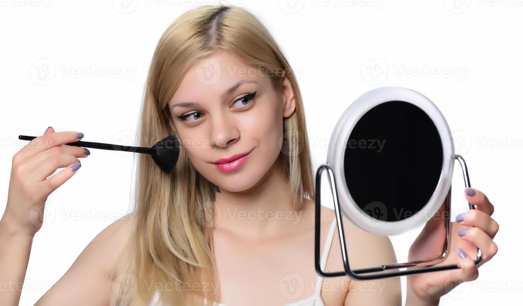 Young woman doing makeup. photo
