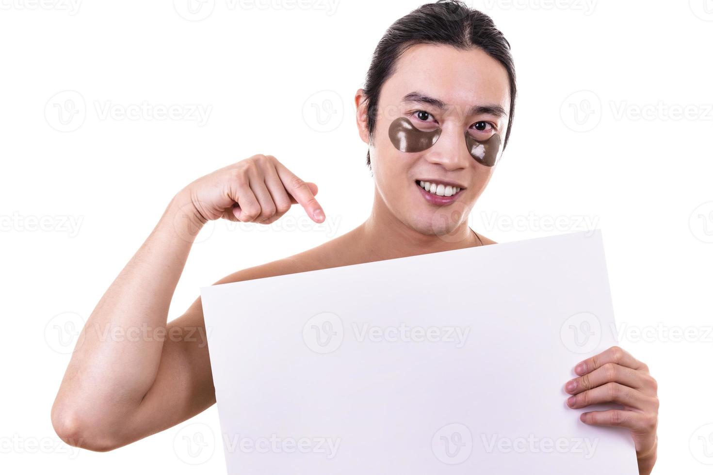 Portrait of young Asian man peeping at the camera holding white blank sign photo