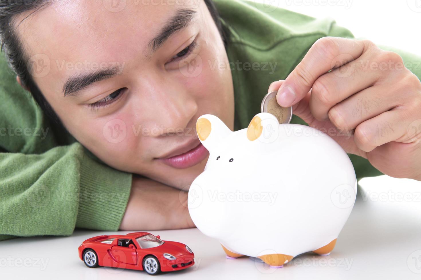 Asian man saving money in a piggy bank photo