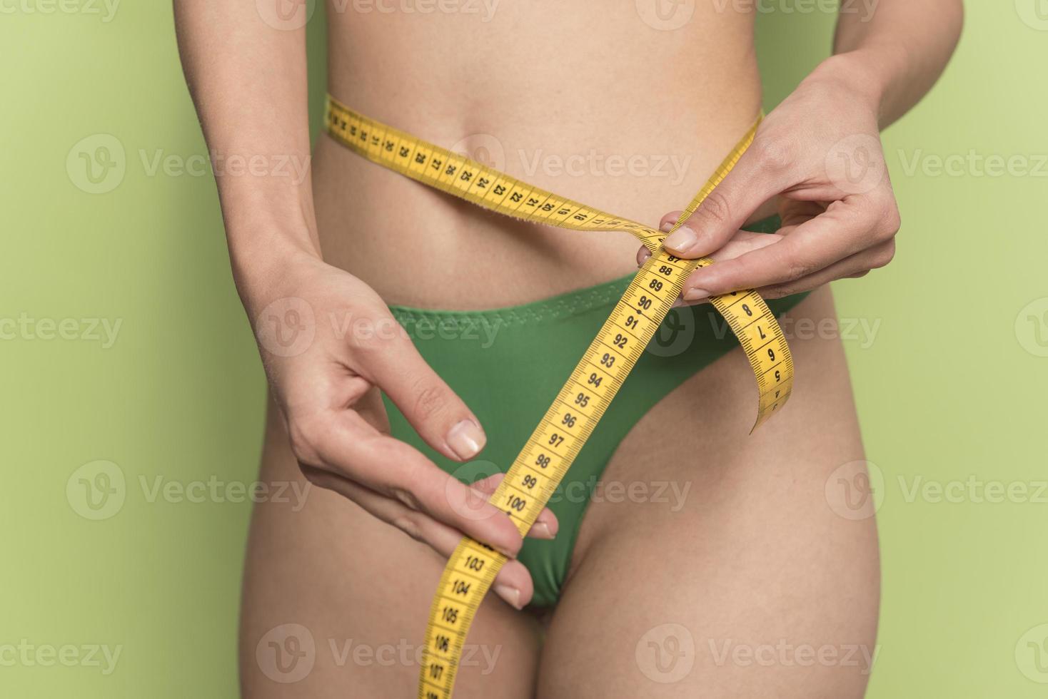 girl measures her volumes with a measuring tape. healthy and beautiful body. Female body, slim waist photo